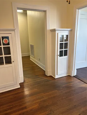 an empty room with wooden floor and entrance