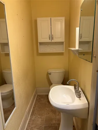 a bathroom with a sink and mirror with toilet