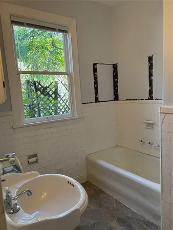a bathroom with a bathtub and a window