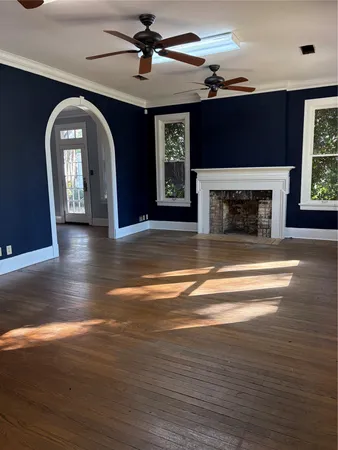 a view of hall with fireplace and wooden floor