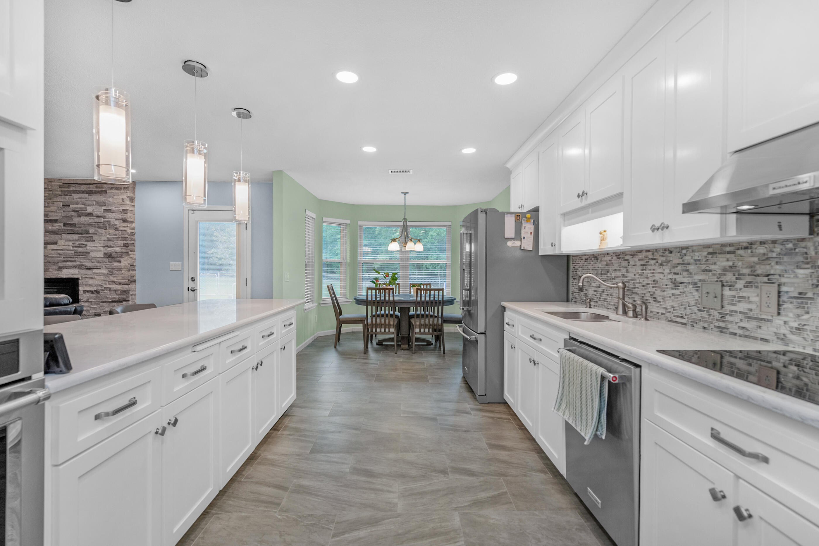 10099 Bellbrook Road Milton, FL 32583 - Photo 11 of 49 a large white kitchen with stainless steel appliances lots of counter space and windows