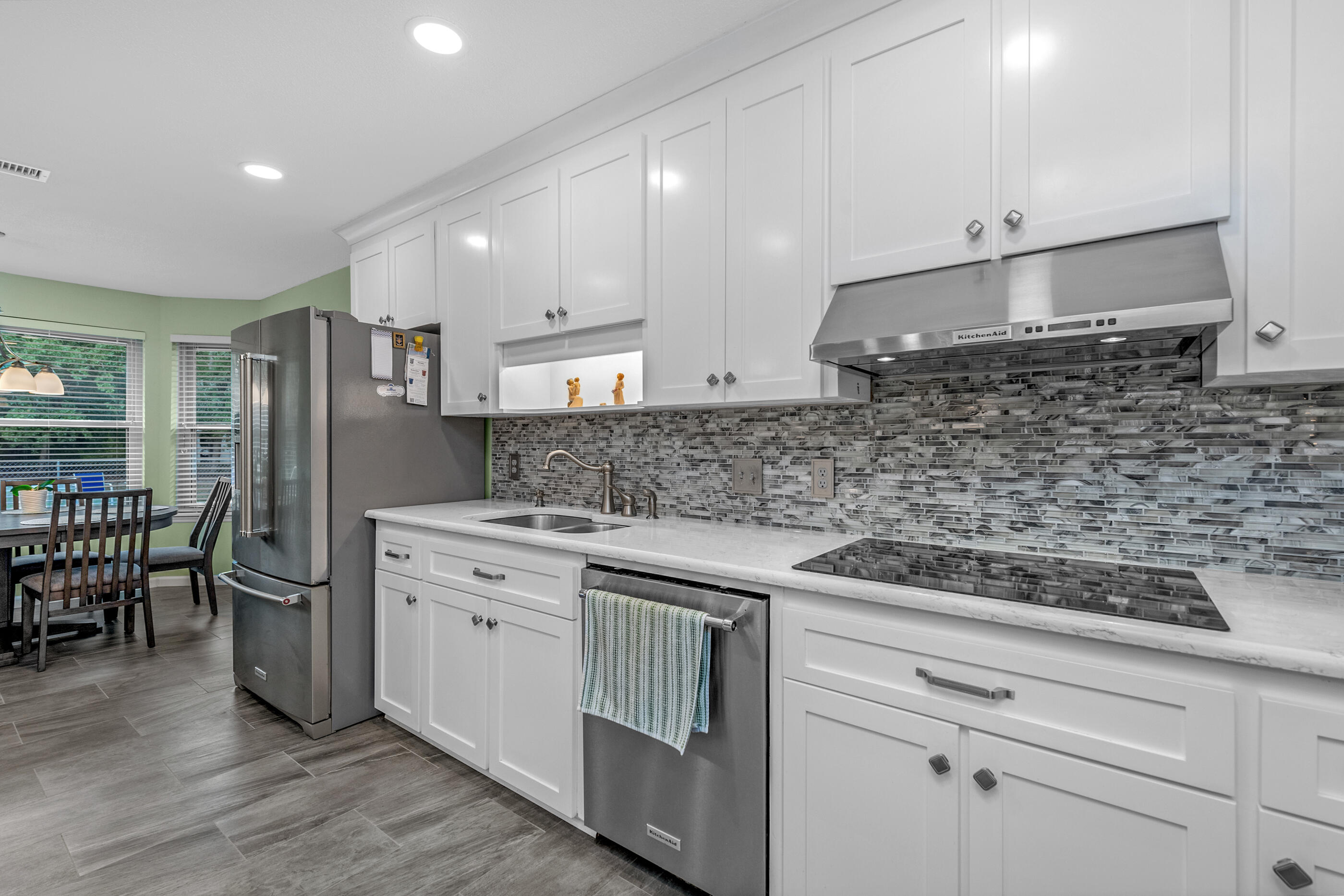 10099 Bellbrook Road Milton, FL 32583 - Photo 12 of 49 a kitchen with stainless steel appliances granite countertop a sink a stove a refrigerator and island with wooden floor
