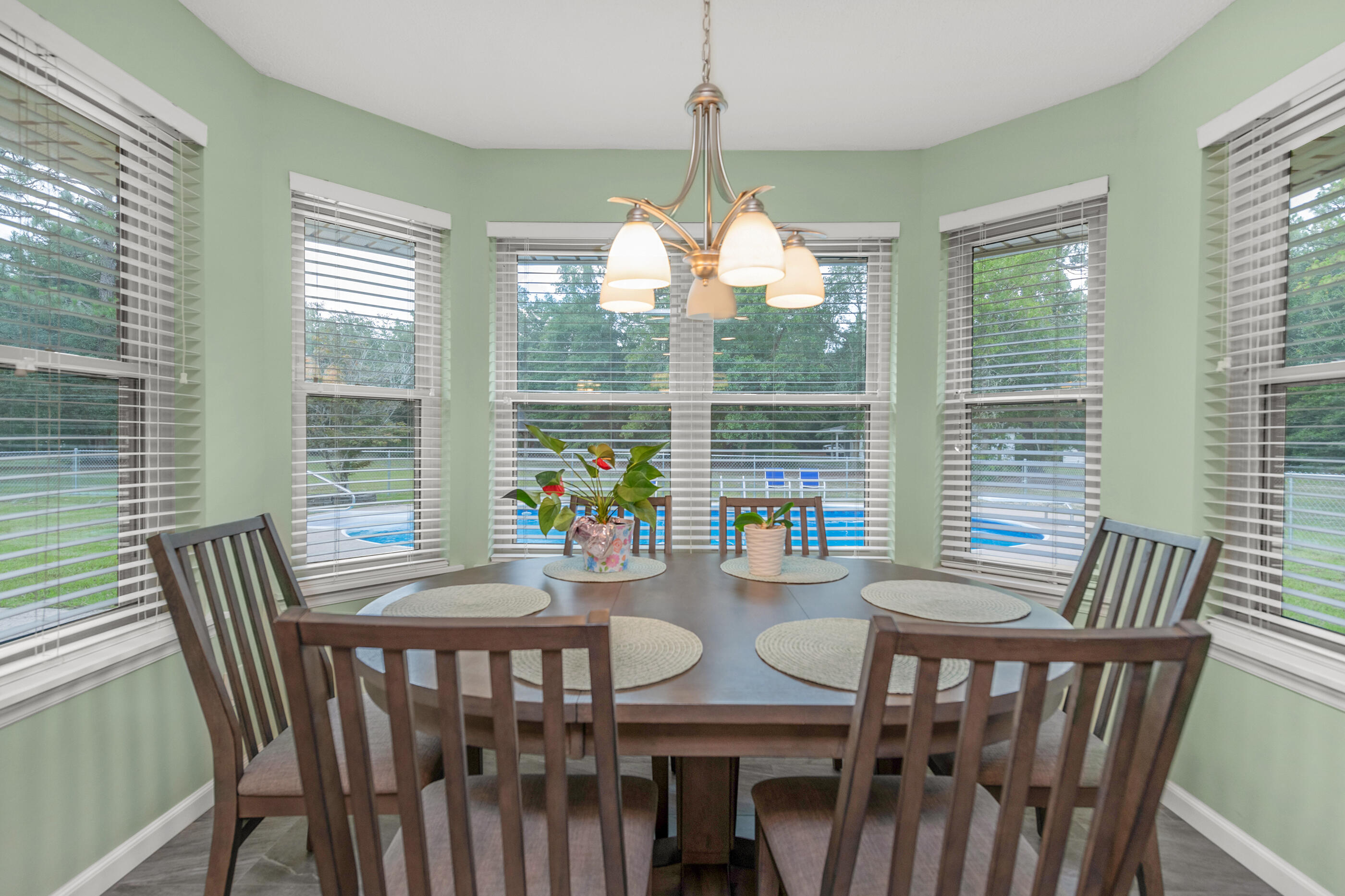 10099 Bellbrook Road Milton, FL 32583 - Photo 31 of 49 a dining room with furniture a chandelier and wooden floor