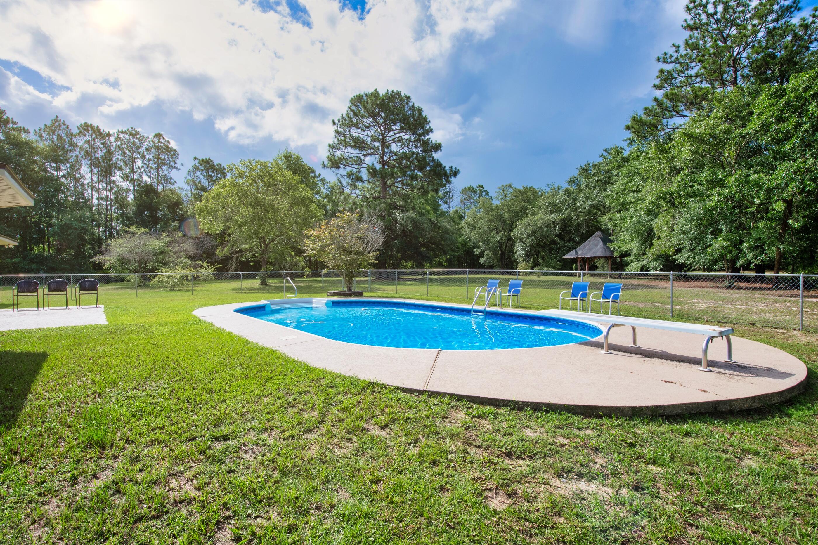 10099 Bellbrook Road Milton, FL 32583 - Photo 40 of 49 a view of a swimming pool with a yard and sitting area