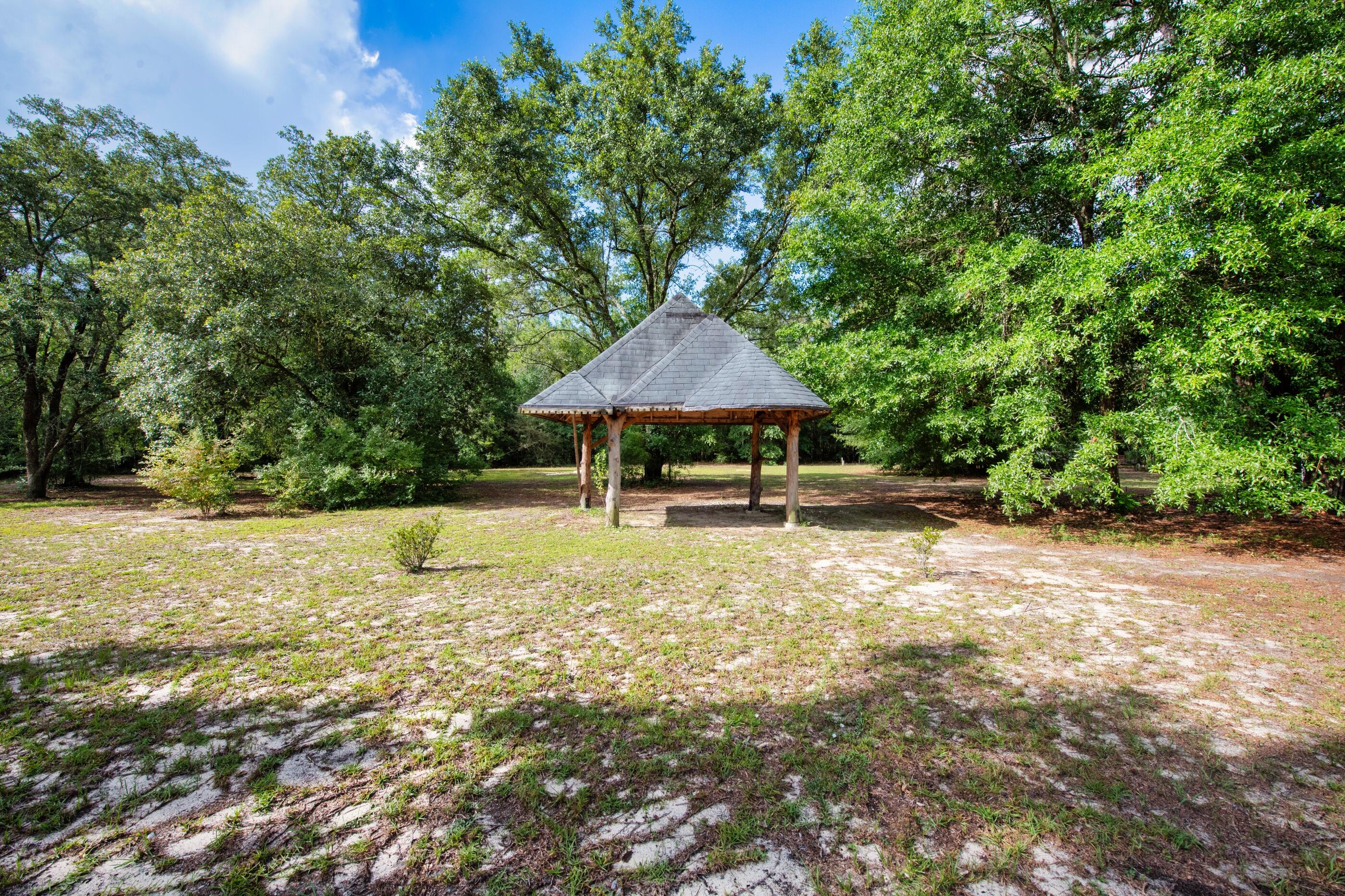 10099 Bellbrook Road Milton, FL 32583 - Photo 44 of 49 a backyard of a house with table and chairs