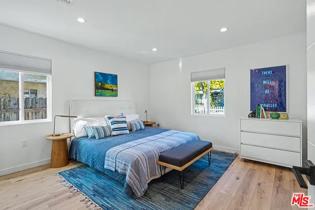 a spacious bedroom with a bed and a dresser