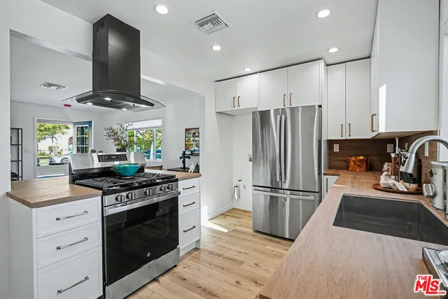 a kitchen with stainless steel appliances granite countertop a stove a refrigerator and a sink
