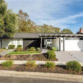 a front view of a house with a yard and potted plants