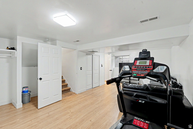 3689 Lasso Loop Circle Magna, UT 84044 - Photo 17 of 26 Finished lower level offering wood-finish flooring, recessed lighting, white trim, and a storage closet with bi-fold doors