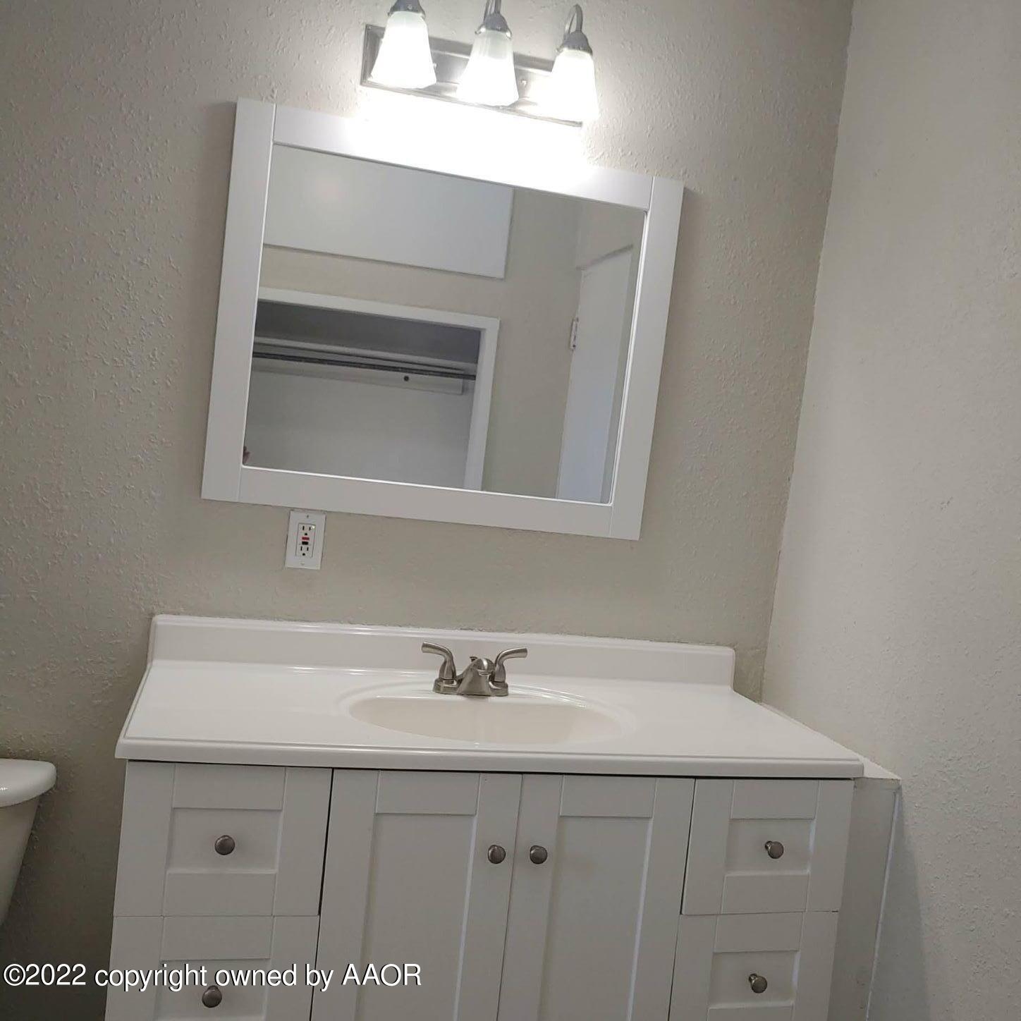 4304 South Hayden Street Amarillo, TX 79110 - Photo 13 of 22 a bathroom with a sink and a mirror