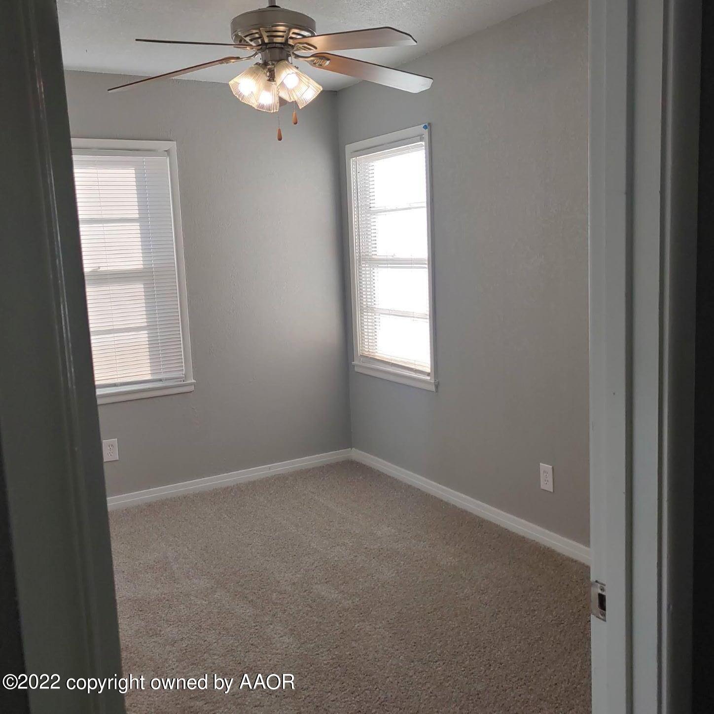 4304 South Hayden Street Amarillo, TX 79110 - Photo 15 of 22 an empty room with windows and fan
