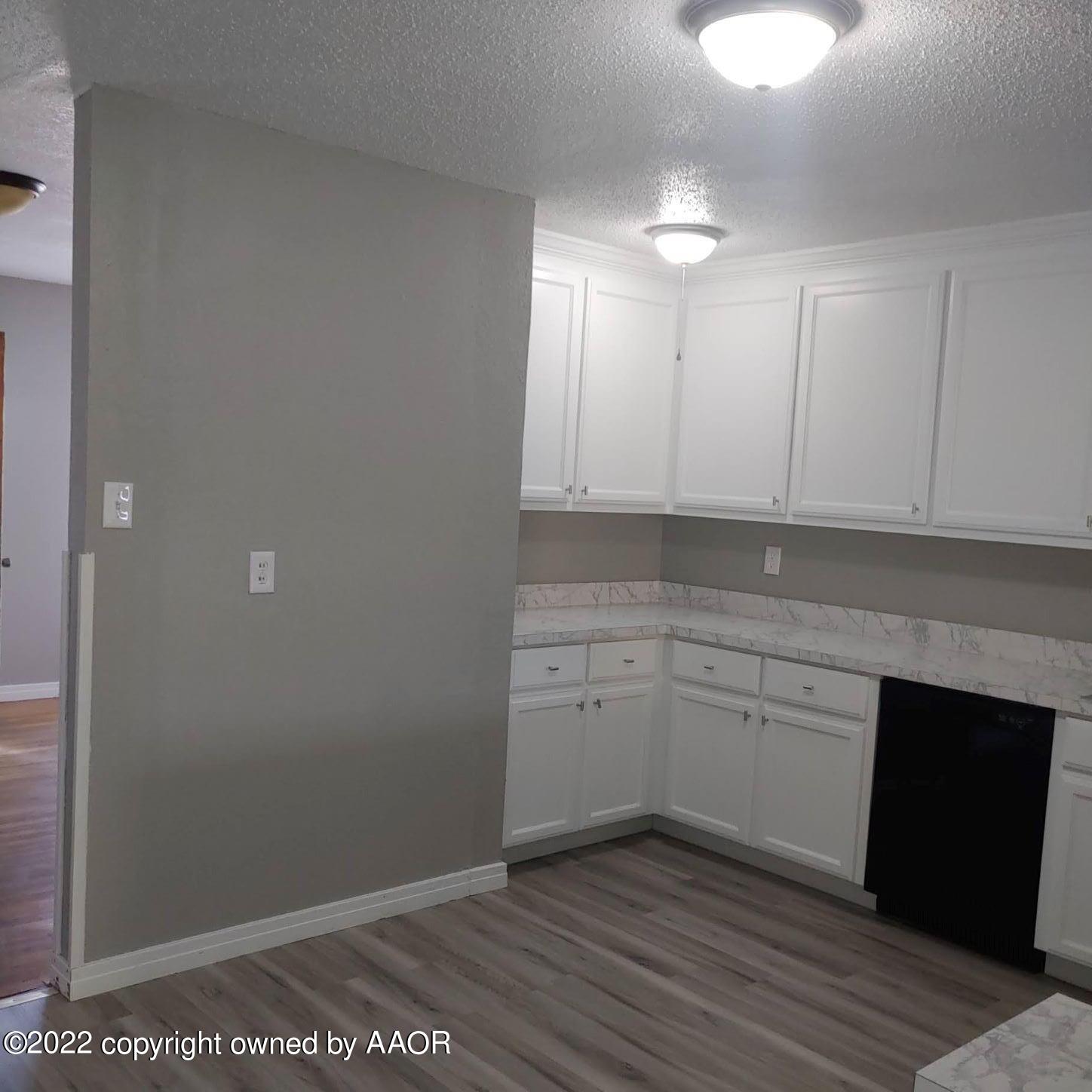 4304 South Hayden Street Amarillo, TX 79110 - Photo 6 of 22 a kitchen with granite countertop white cabinets and white appliances