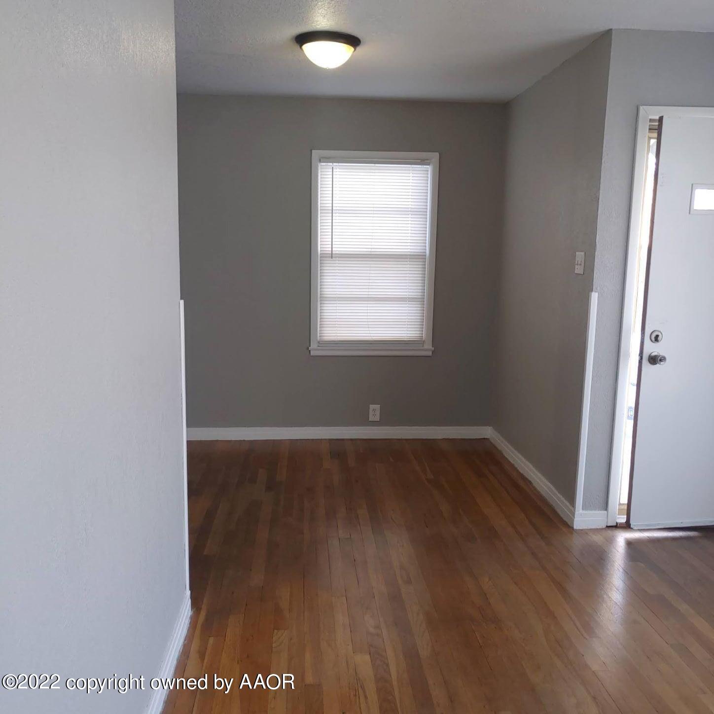 4304 South Hayden Street Amarillo, TX 79110 - Photo 8 of 22 an empty room with wooden floor and windows