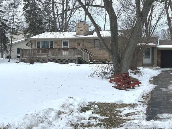 a view of a house with a yard covered in snow