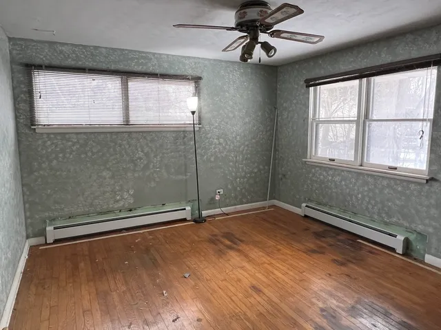 an empty room with window and wooden floor