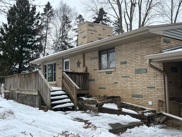 a backyard of a house with wooden fence and large trees