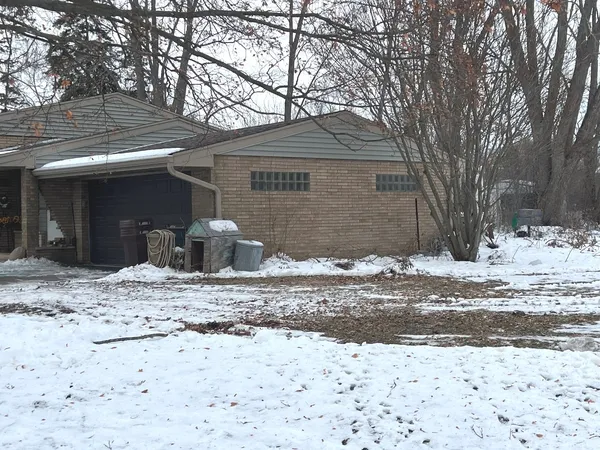 a front view of a house with a yard covered in snow