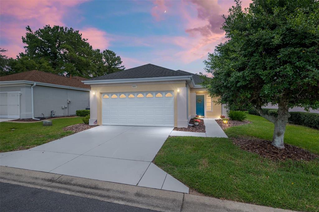a front view of a house with a yard and a garage