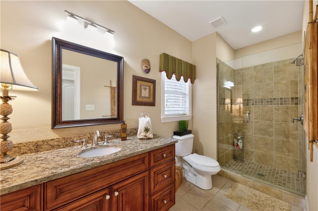 110 Roxbury Row Alpharetta, GA 30004 - Photo 26 of 45 a bathroom with a granite countertop sink toilet a mirror and shower
