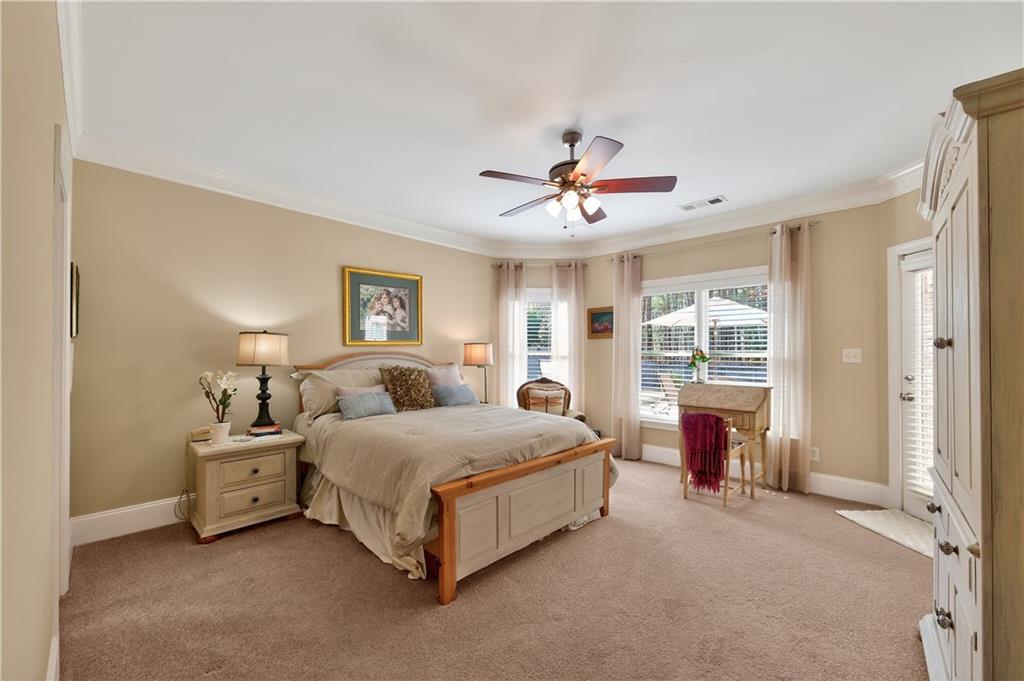 110 Roxbury Row Alpharetta, GA 30004 - Photo 27 of 45 a spacious bedroom with a bed a chandelier and a window
