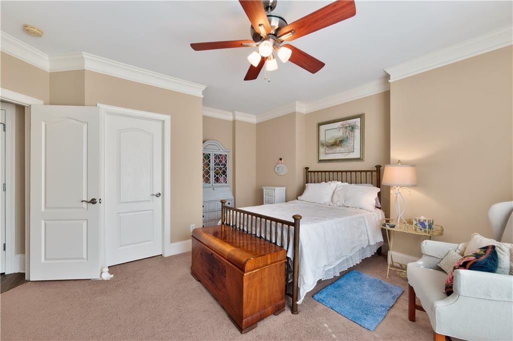 110 Roxbury Row Alpharetta, GA 30004 - Photo 30 of 45 a spacious bedroom with a bed and a chandelier