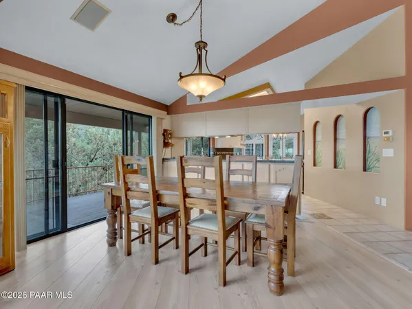 a kitchen with stainless steel appliances a table and chairs in it