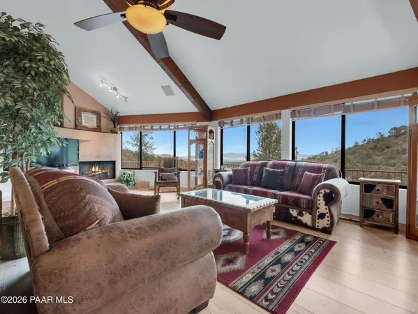 a living room with furniture a fireplace and a floor to ceiling window