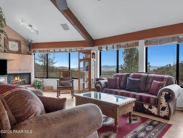 a living room with furniture a flat screen tv and a floor to ceiling window