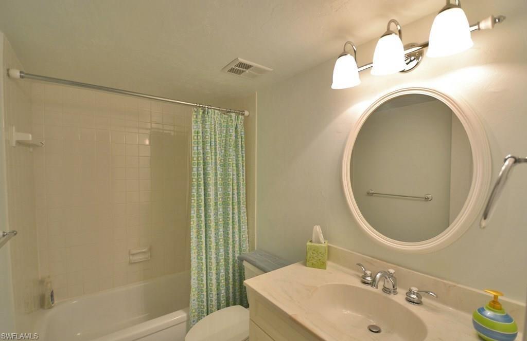 307 Goodlette-Frank Road, Unit 506B Naples, FL 34102 - Photo 17 of 25 a bathroom with a sink mirror toilet and shower