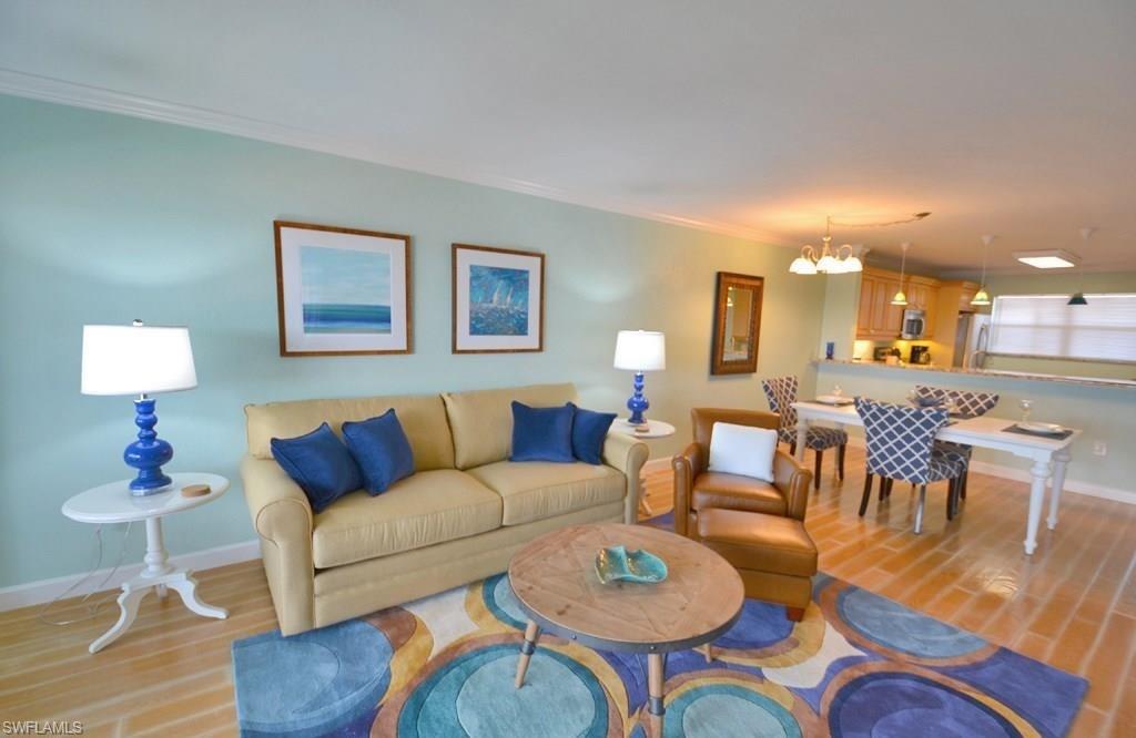 307 Goodlette-Frank Road, Unit 506B Naples, FL 34102 - Photo 5 of 25 a living room with furniture and a lamp