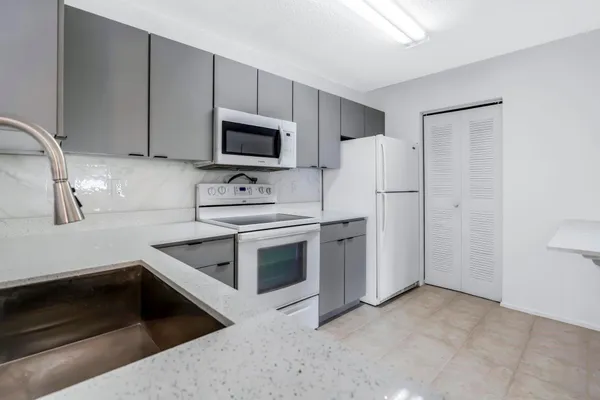 a kitchen with stainless steel appliances white cabinets and a sink
