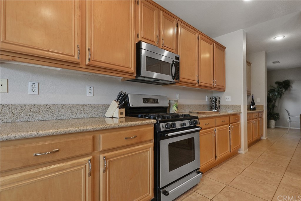 82551 Grant Drive Indio, CA 92201 - Photo 12 of 45 a kitchen with stainless steel appliances granite countertop a stove a microwave and cabinets