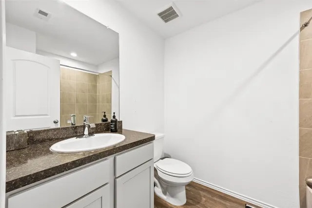 a bathroom with a granite countertop sink a toilet and a mirror