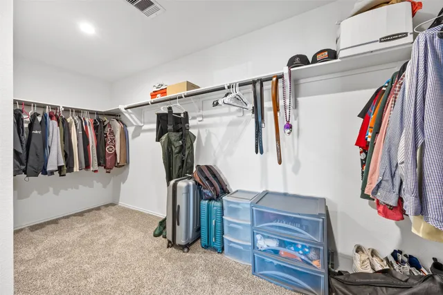 a view of walk in closet with clothes and shoes