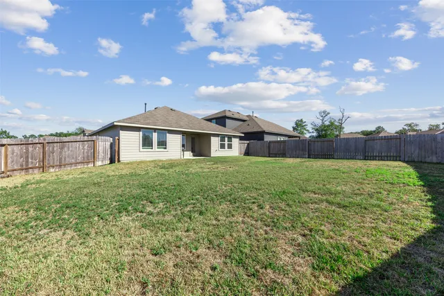 a view of an house with backyard and a tree