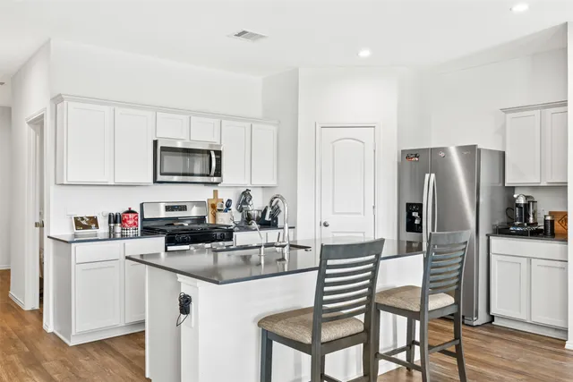 a kitchen with white cabinets and stainless steel appliances