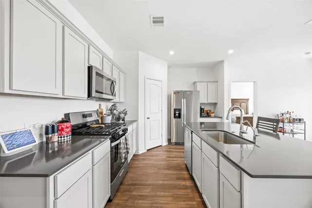 a kitchen with stainless steel appliances granite countertop a sink stove and refrigerator