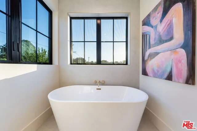 a white bath tub sitting next to a small window