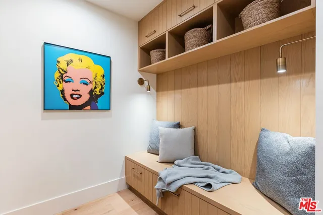 a bedroom with a bed and painting on the wall