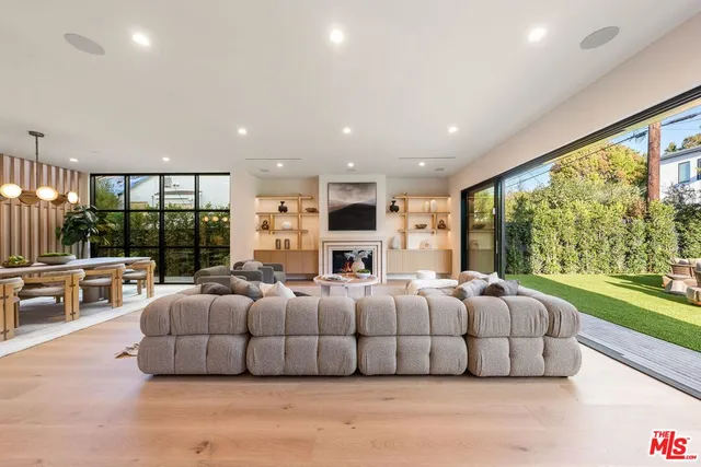 a living room with furniture large windows and a flat tv screen