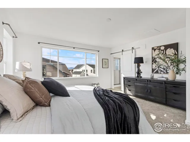 a bedroom with a bed and dresser with mirror