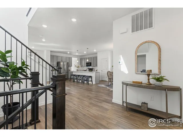 a living room with wooden floor and stairs