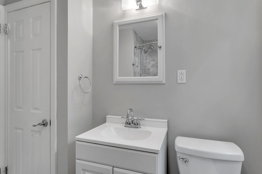 97 Old Brook Road Springfield, MA 01118 - Photo 23 of 42 a bathroom with a toilet a sink and mirror