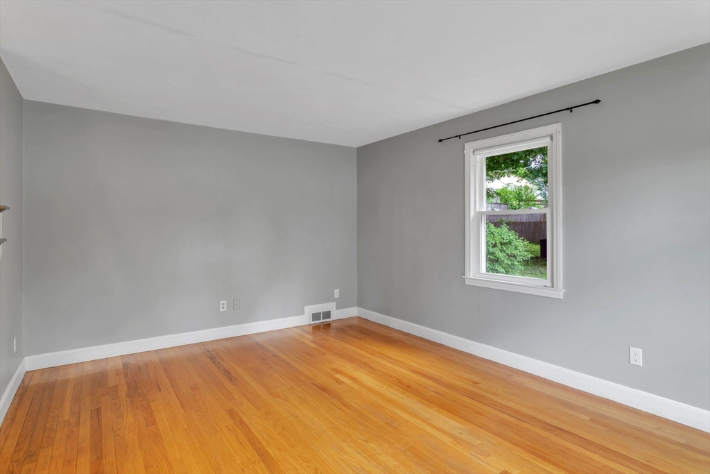 97 Old Brook Road Springfield, MA 01118 - Photo 6 of 42 a view of an empty room with wooden floor and a window