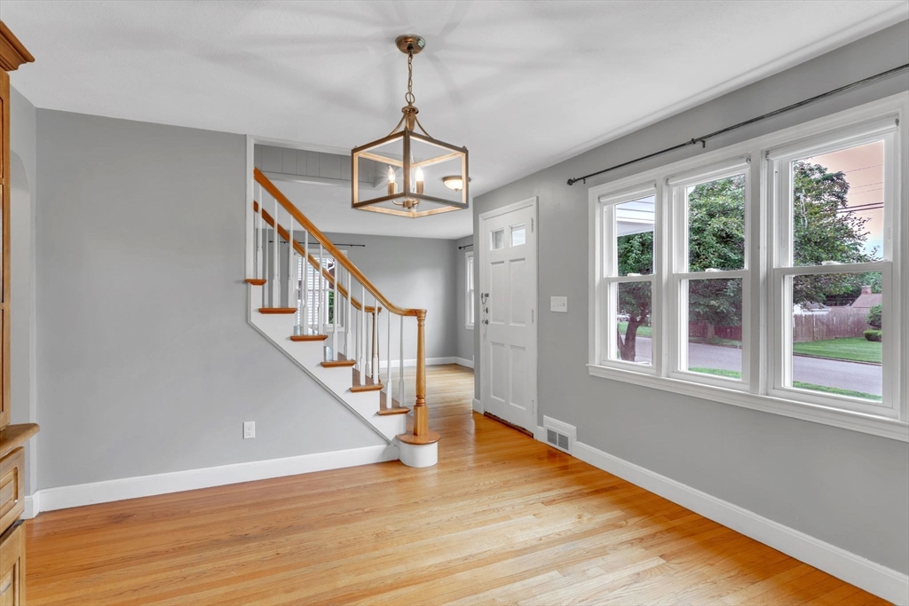97 Old Brook Road Springfield, MA 01118 - Photo 7 of 42 a view of an empty room with wooden floor windows and a chandelier