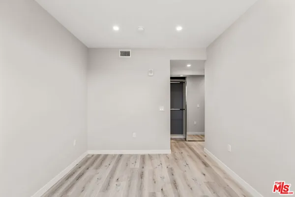 a view of an empty room with wooden floor