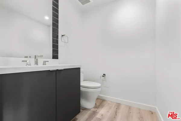 a bathroom with a sink a toilet and mirror