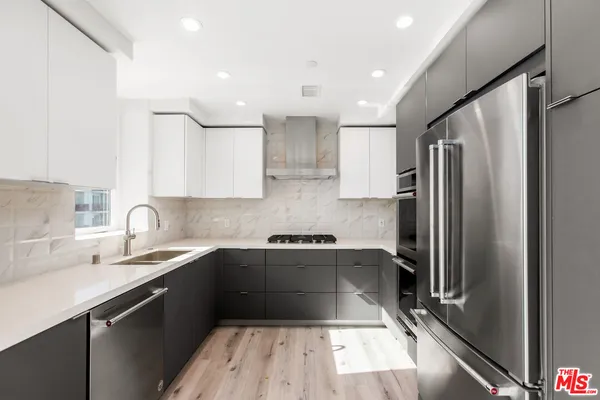 a kitchen with a sink a refrigerator and stainless steel appliances