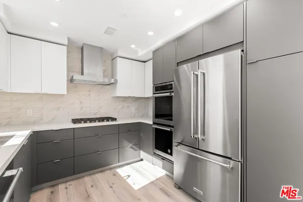 a kitchen with stainless steel appliances granite countertop a refrigerator sink and stove