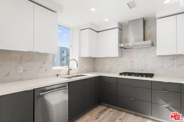 a kitchen with a sink dishwasher and cabinets